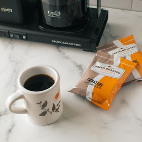 Fresh Roasted Coffee drip pour-over setup with a hot mug.