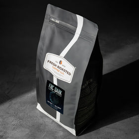 Close-up of glossy FRC Dark Roast beans highlighting rich color and notes