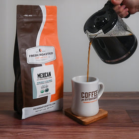 Fresh Roasted Coffee Organic Mexican cup with steam emphasizing mild pear notes.