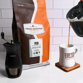 Fresh Roasted Coffee Peru Cajamarca whole beans closeup highlights glossy beans ready to grind.
