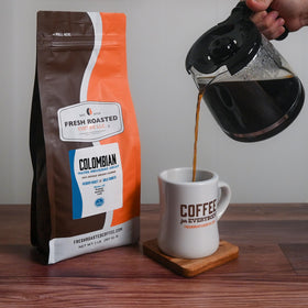 Fresh Roasted Coffee Swiss Water Decaf Colombian 2 lb cup with steam emphasizes inviting aroma for a morning ritual.