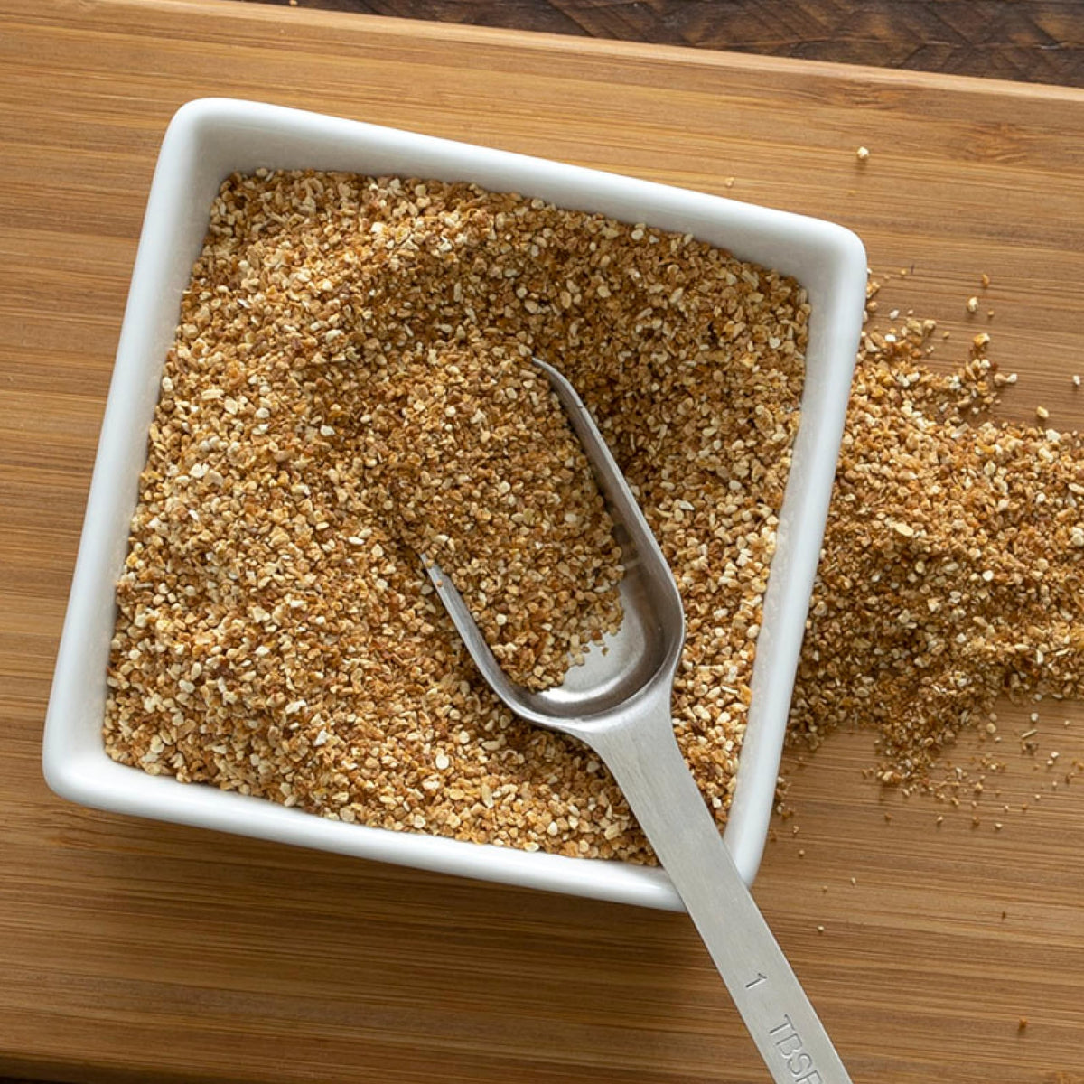 Diced texture of Frontier Co-op orange peel granules on spoon for rubs