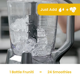 Fruniti Mango Smoothie Mix being stirred with water and ice for a refreshing drink.