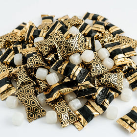 Fun Express black and gold wrapped butter mints on an elegant wedding candy buffet.