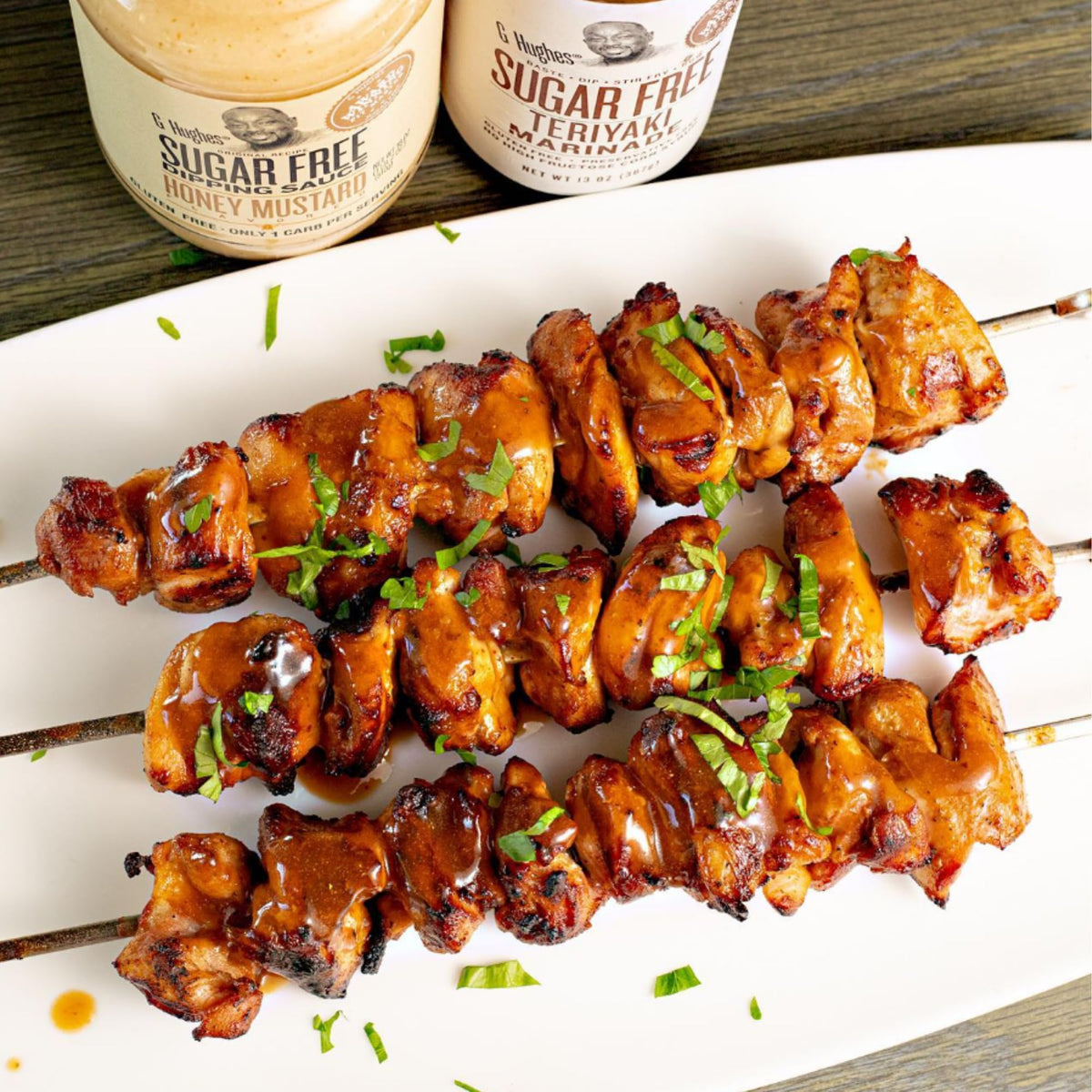 G Hughes Teriyaki Marinade glazing chicken skewers on the grill.