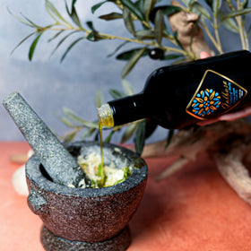 Bottle on a table with harvest imagery, emphasizing family producer origin.