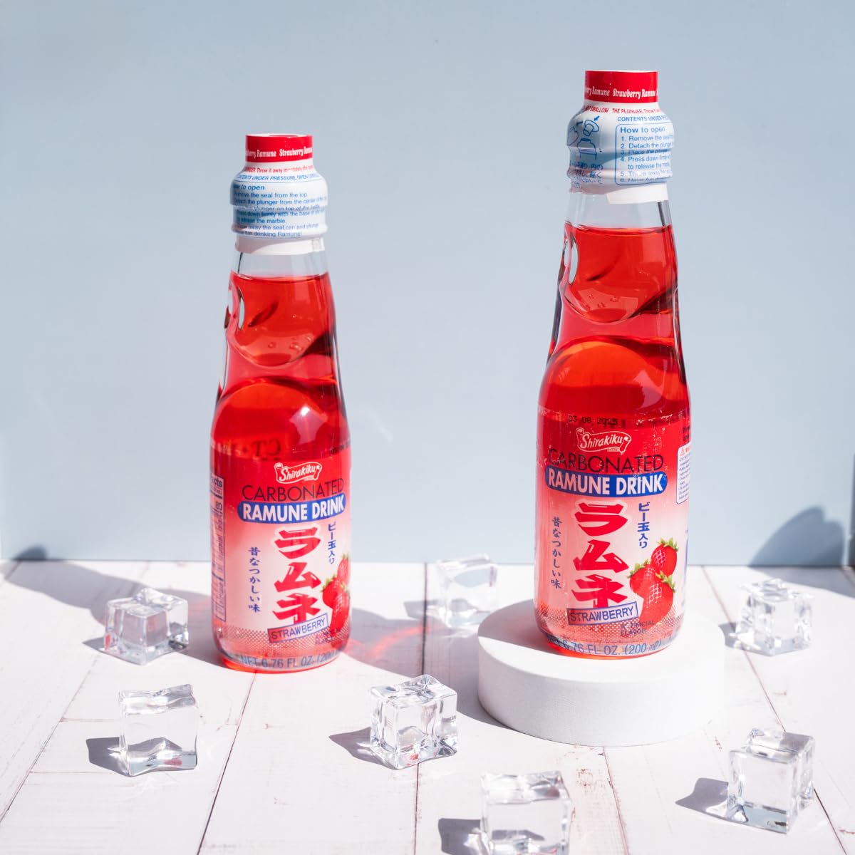 Generic Ramune glass bottle on table, cold and refreshing strawberry flavor.