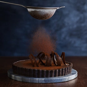 Ghirardelli Majestic Premium Cocoa Powder poured into a hot cocoa mug