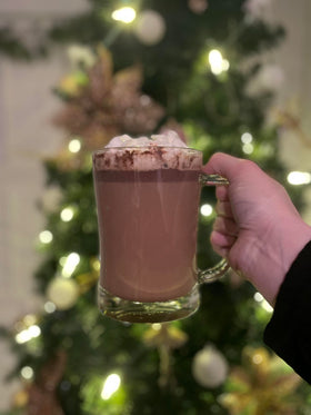 Ghirardelli powder being poured into a mug for a dark mocha beverage.