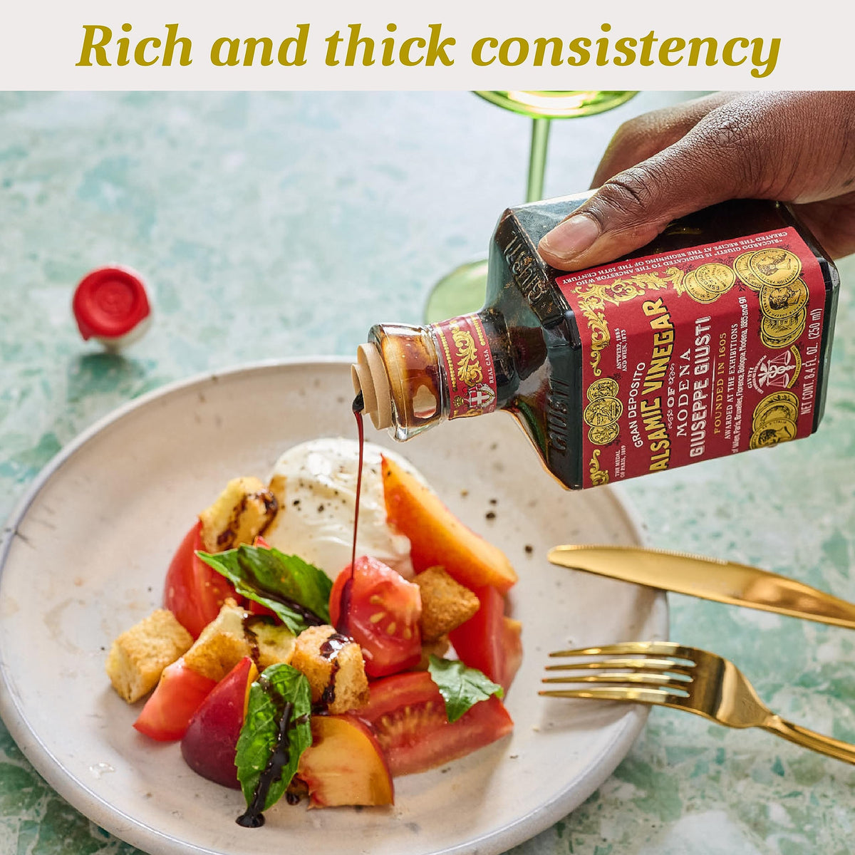 Pouring Giusti balsamic dressing over greens for a vibrant salad.
