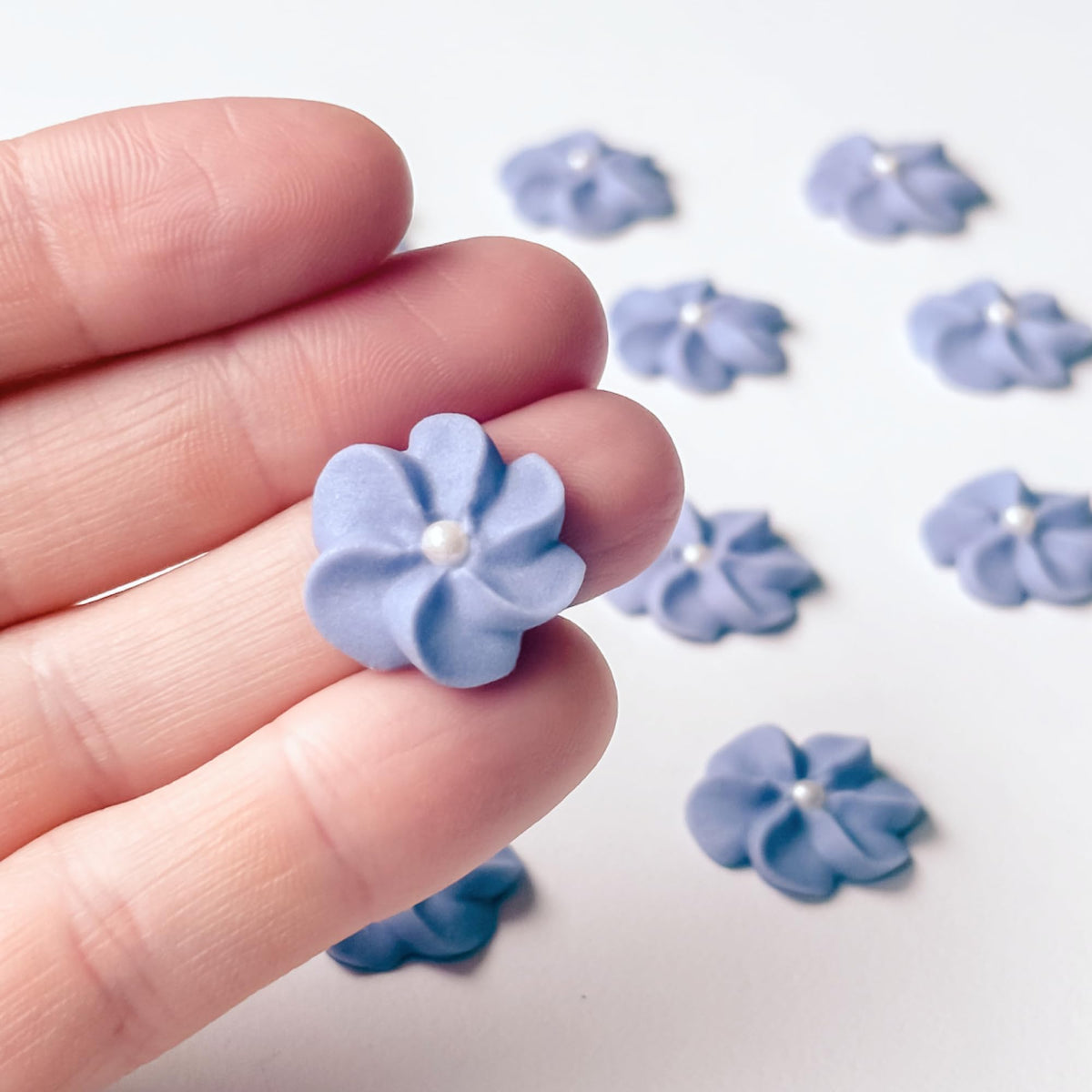 Global Sugar Art mini edible royal icing flowers for cupcakes add delicate purple decoration.