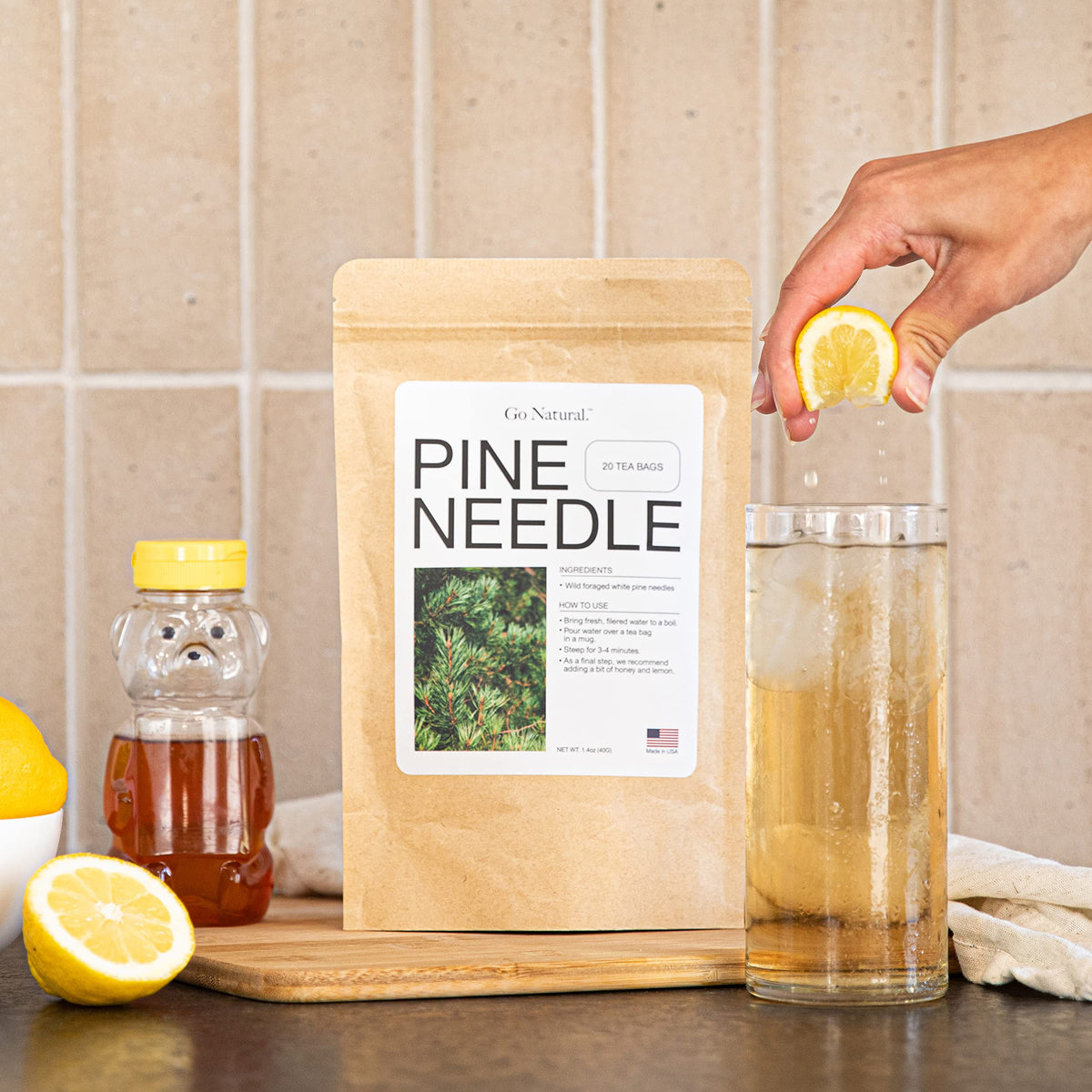 Go Natural Pine Needle Tea brewed cup with steam, conveying daily ritual and wellness.