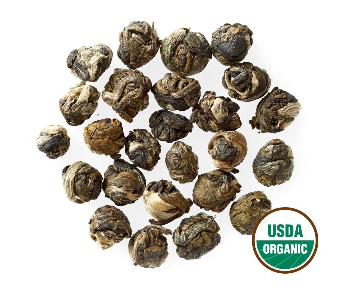 Close-up of hand-rolled Jasmine Dragon Pearl ready to brew by Golden Moon Tea.