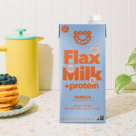 Good Karma Vanilla Flaxmilk +Protein carton on pantry shelf, convenient vegan drink.