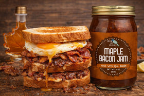 Green Jay Gourmet Maple Bacon Jam on a charcuterie board with cheeses