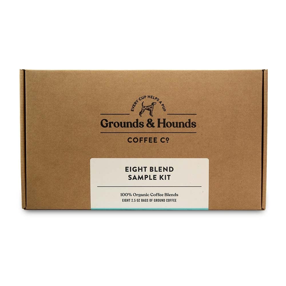 A warm cup of Grounds & Hounds coffee beside the sample kit for tastings.