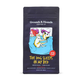 Grounds & Hounds coffee bag on a cozy dog bed, ideal for pet-friendly mornings.