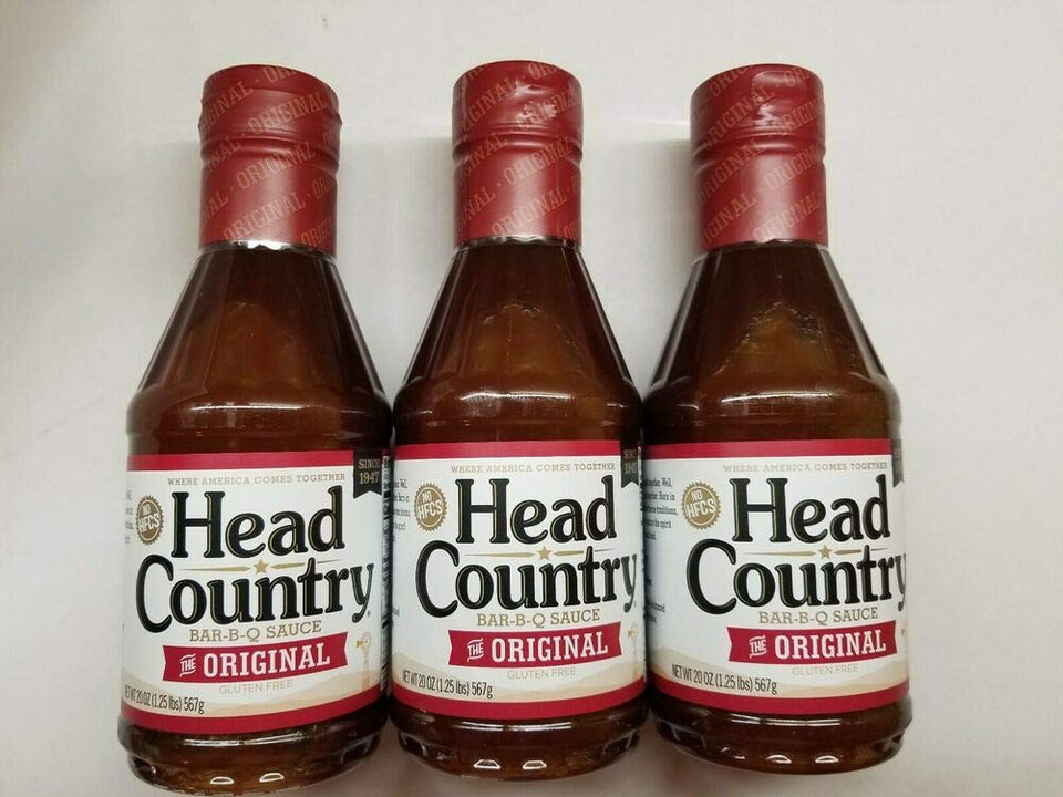 Head Country Original BBQ Sauce bottle pouring on ribs for rich, smoky flavor.