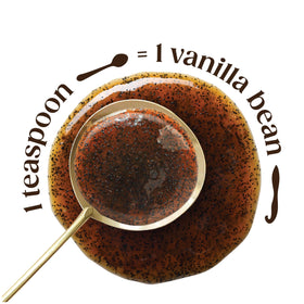 Pouring Heilala Vanilla Bean Paste from a spoon for easy baking preparation.