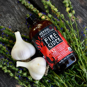 Herbal Revolution Fire Cider pouring shot highlights warming uses in dressings.