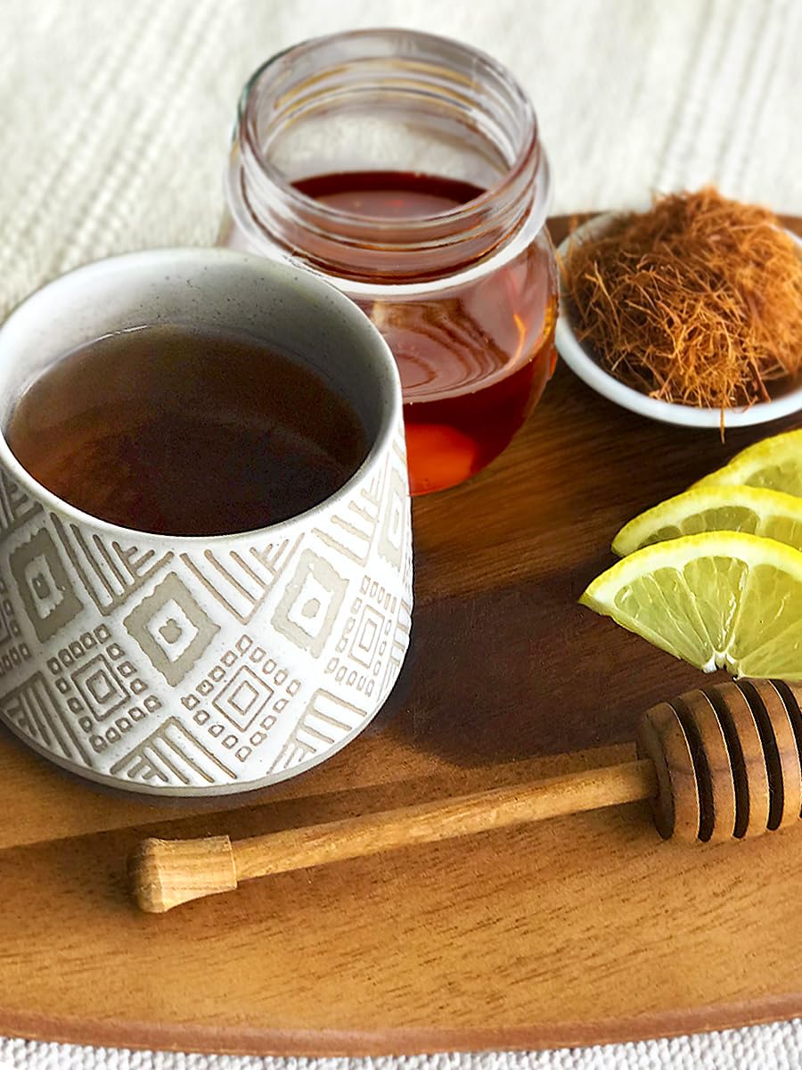 Kettle pouring Cat's Claw Tea into a cup