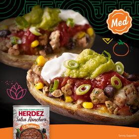Herdez Ranchera Salsa Medium being poured over fajitas for sizzling flavor
