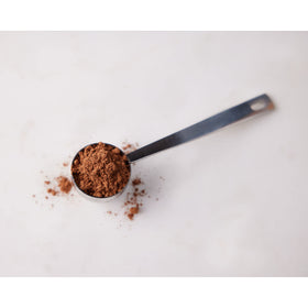 HERSHEY'S unsweetened cocoa powder measuring into batter for brownies