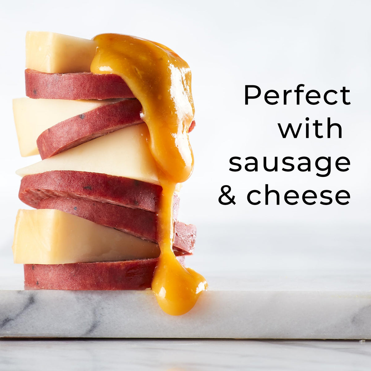 Hickory Farms Honey Pineapple Mustard on a charcuterie board with meats and cheese.