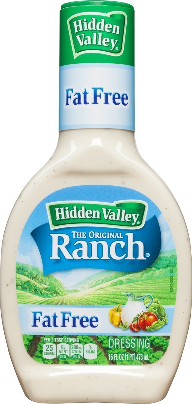 Hidden Valley Fat Free Ranch bottle pouring over a fresh salad, highlighting lower-fat dressing.