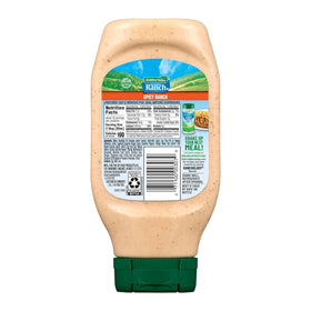 Hidden Valley Original Spicy Ranch bottle pouring over fresh greens.