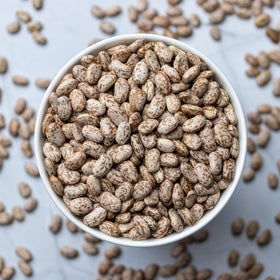 Close-up of dry pinto beans with smooth texture for soaking and simmering.