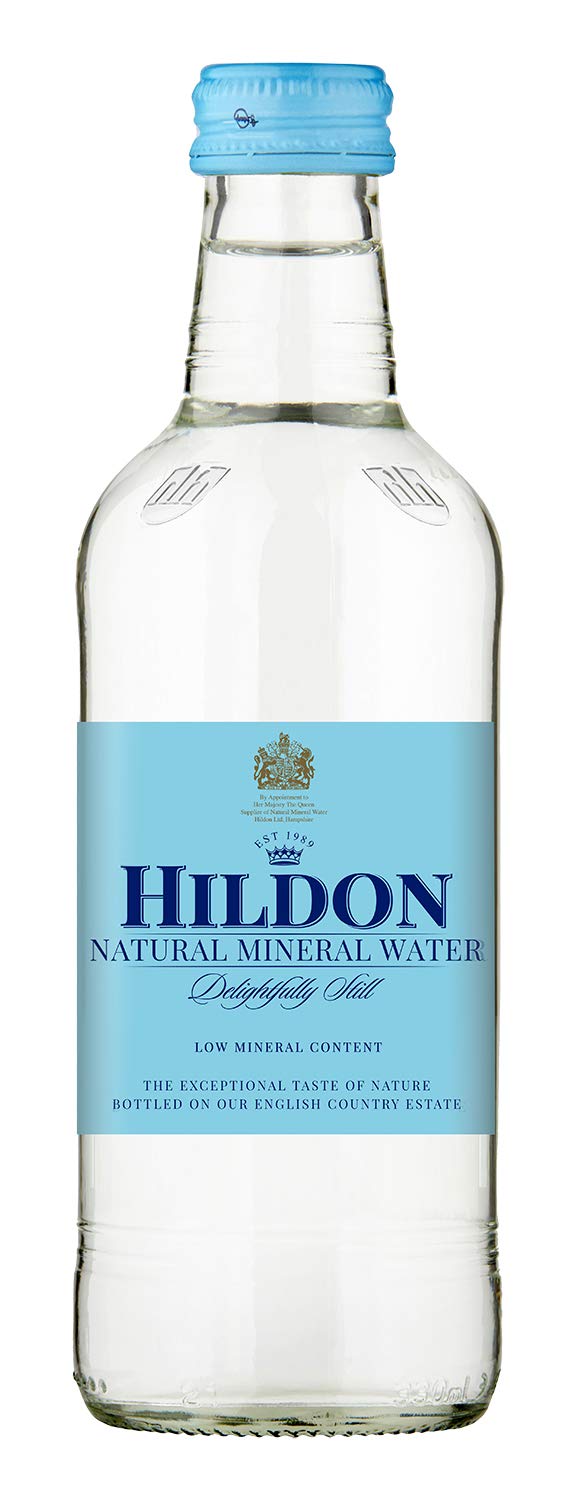 Hildon Delightfully Still six-pack bottles on a kitchen counter for family refreshment.