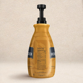 Pouring Hollander caramel sauce from the pump to swirl into a latte.
