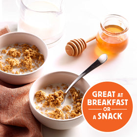 Pouring honey roasted granola clusters over yogurt with Honey Bunches of Oats