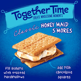 Graham crackers beside a campfire setup for camping snacks.