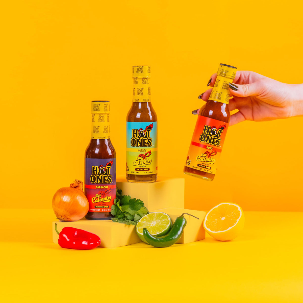 Hot Ones Caliente Trio Rojo bottle pour—bright citrus heat ideal for tacos and breakfast.
