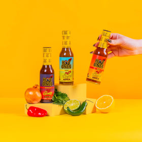 Hot Ones Caliente Trio Rojo bottle pour—bright citrus heat ideal for tacos and breakfast.