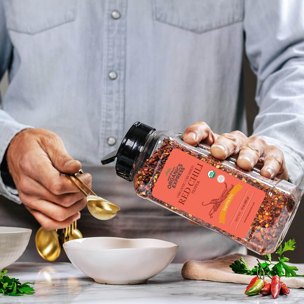 HQOExpress chili flakes pouring from jar to season a dish.