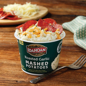 Family dinner scene with Idahoan cups suggests quick side options for weeknights.