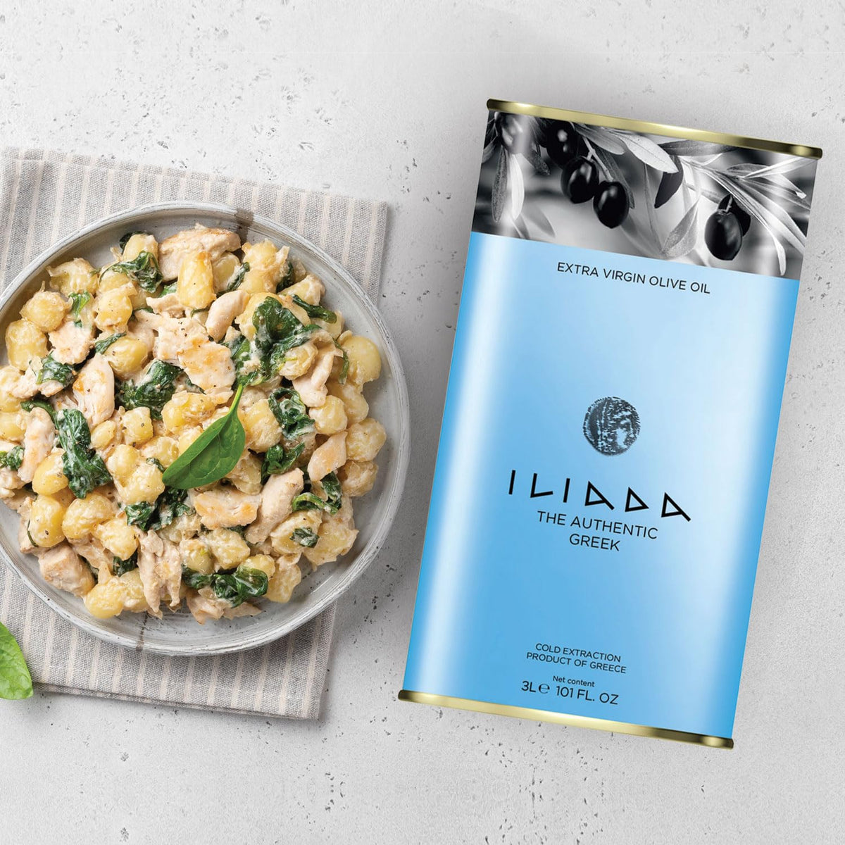 ILIADA olive oil bottle with dish showcasing Mediterranean flavor.