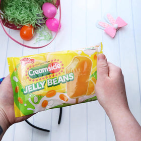 Imaginings 3 orange cream flavor jelly beans with popsicle-inspired swirls.