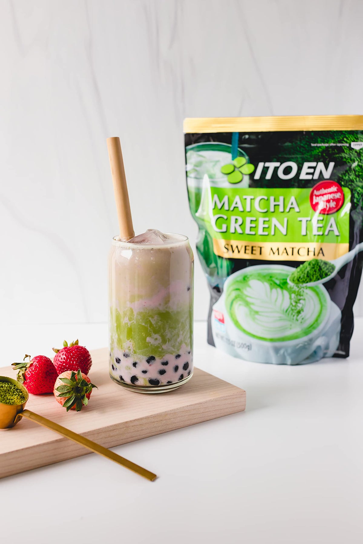 Ito En Matcha Sweet Powder beside a glass of iced tea for a green refreshment.