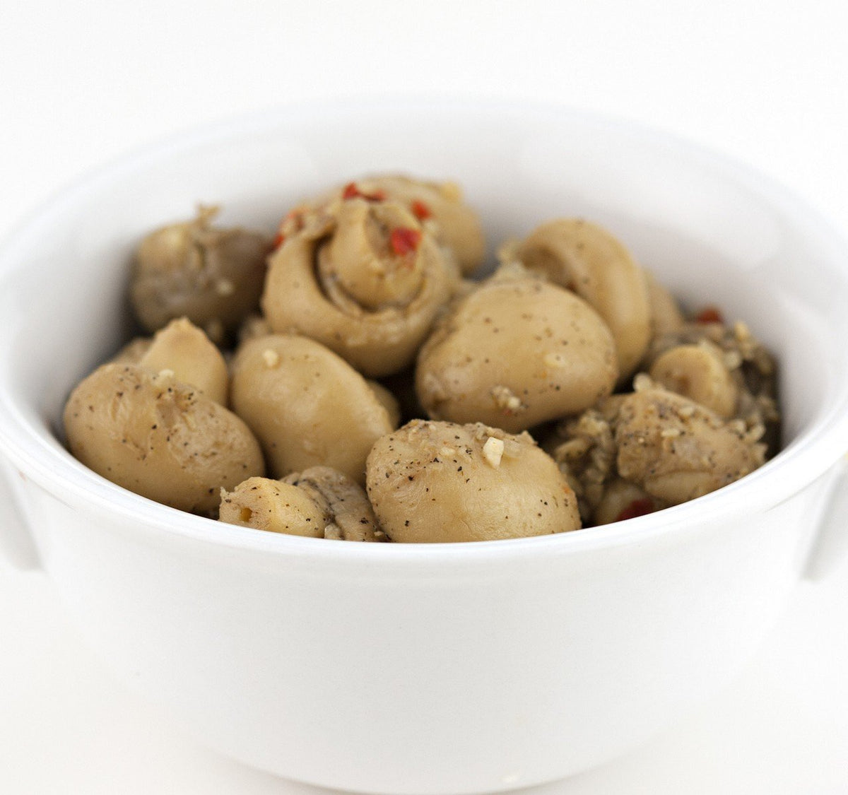 Close-up of Jake & Amos marinated mushrooms in herb marinade