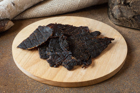 Ostrich jerky close-up texture highlighting natural quality and seasoning.