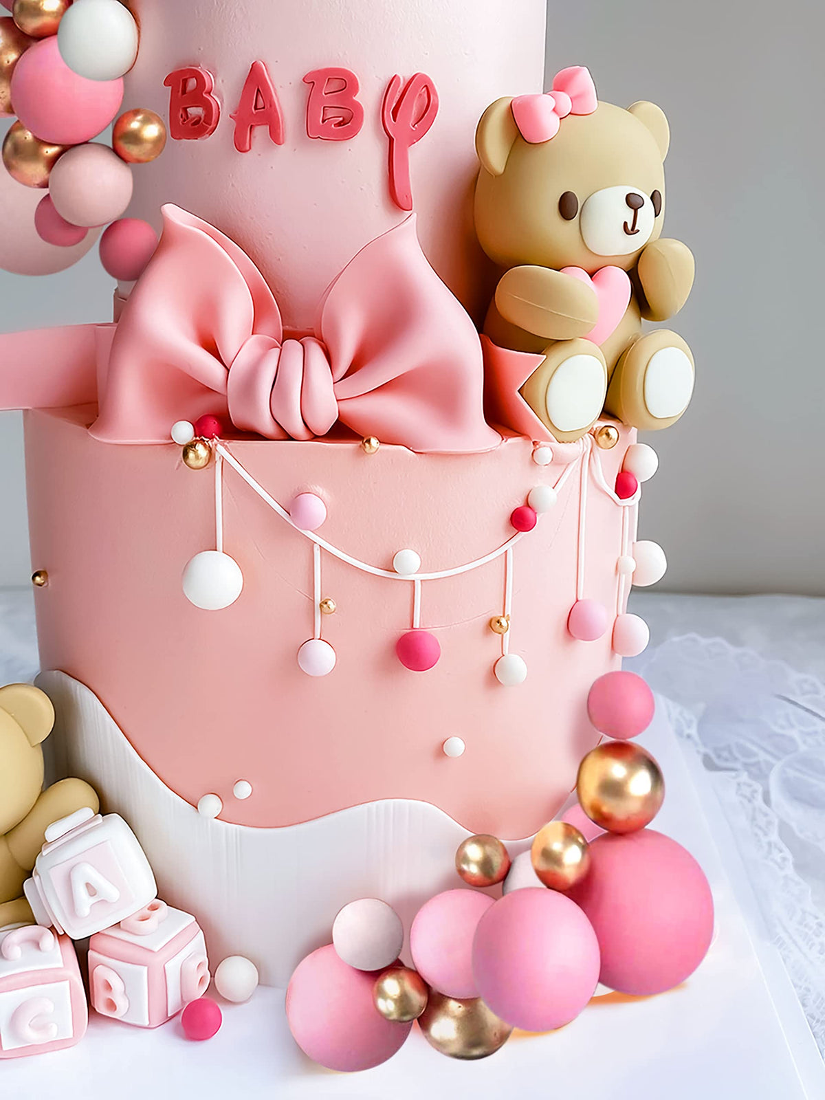 JeVenis white balls cake decor provides clean contrast for pastel party themes.