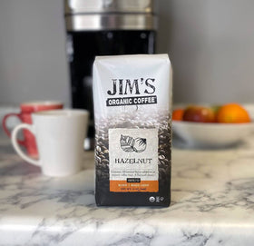 Jim's Organic Coffee hazelnut steaming cup showing aroma and warmth