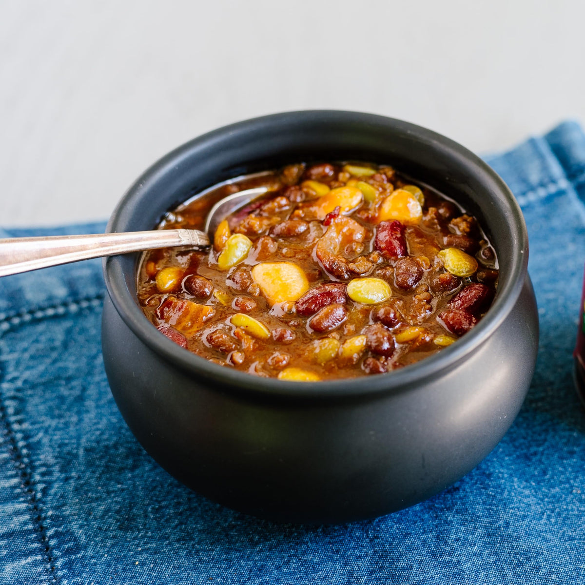Joan of Arc Spicy Chili Beans on shelf highlights bulk convenience.