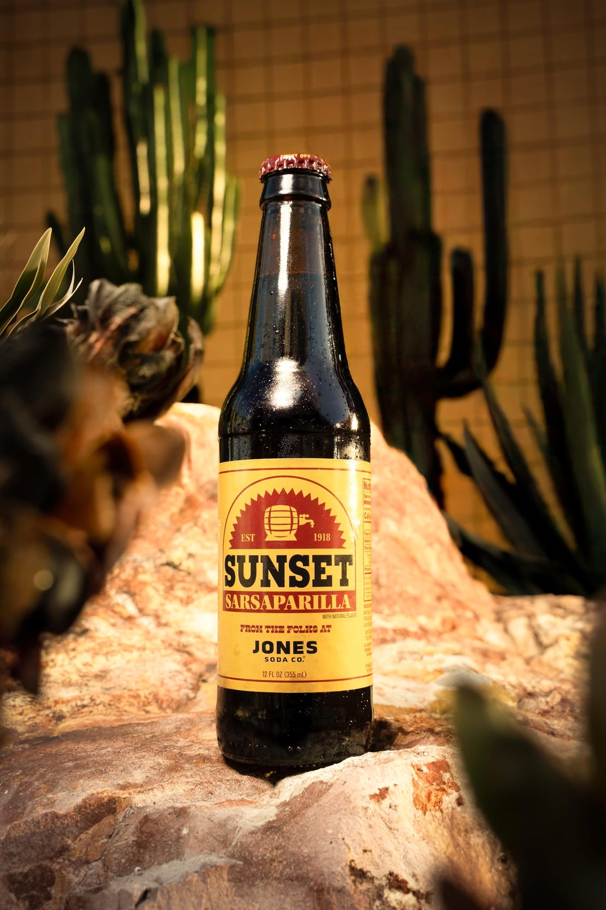 Jones Soda Fallout Sunset Sarsaparilla bottle pouring into a glass, crisp fizz.