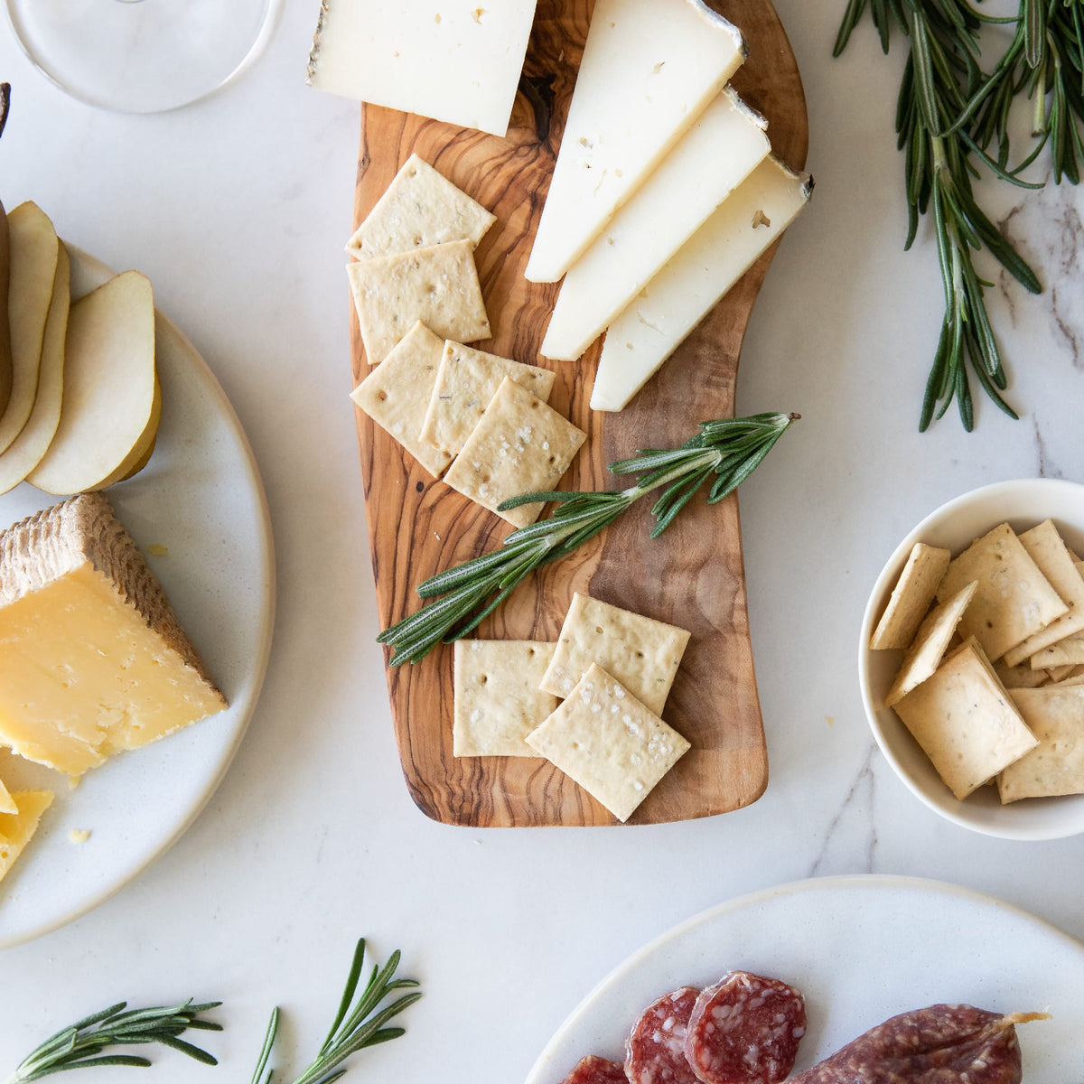 Crackers with rosemary visible, aromatic herb notes enhancing snacking.