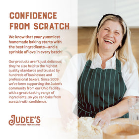 Judee's Gluten Free Dried Egg White Protein Powder with measuring cups on a clean countertop.